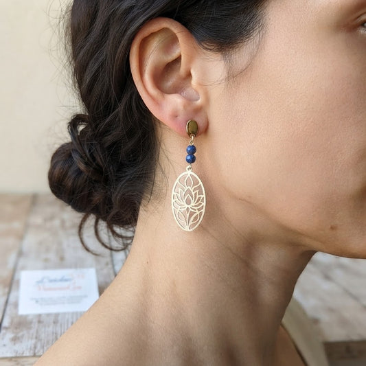 Boucles d'oreilles lotus ajouré en acier inoxydable et lapis-lazuli portées, illustrant leur rendu élégant et leur taille.