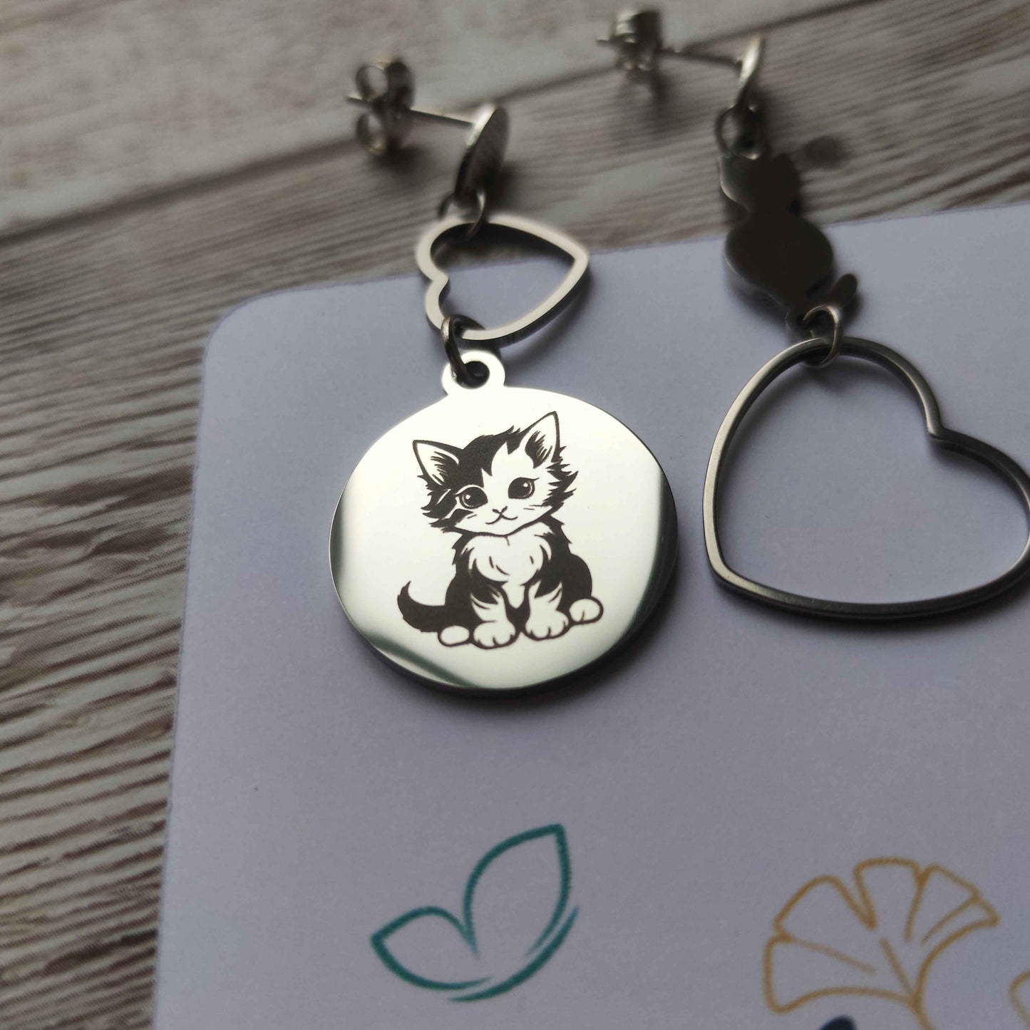 Gros plan gravure précision chat mignon sur boucle d'oreille artisanale.