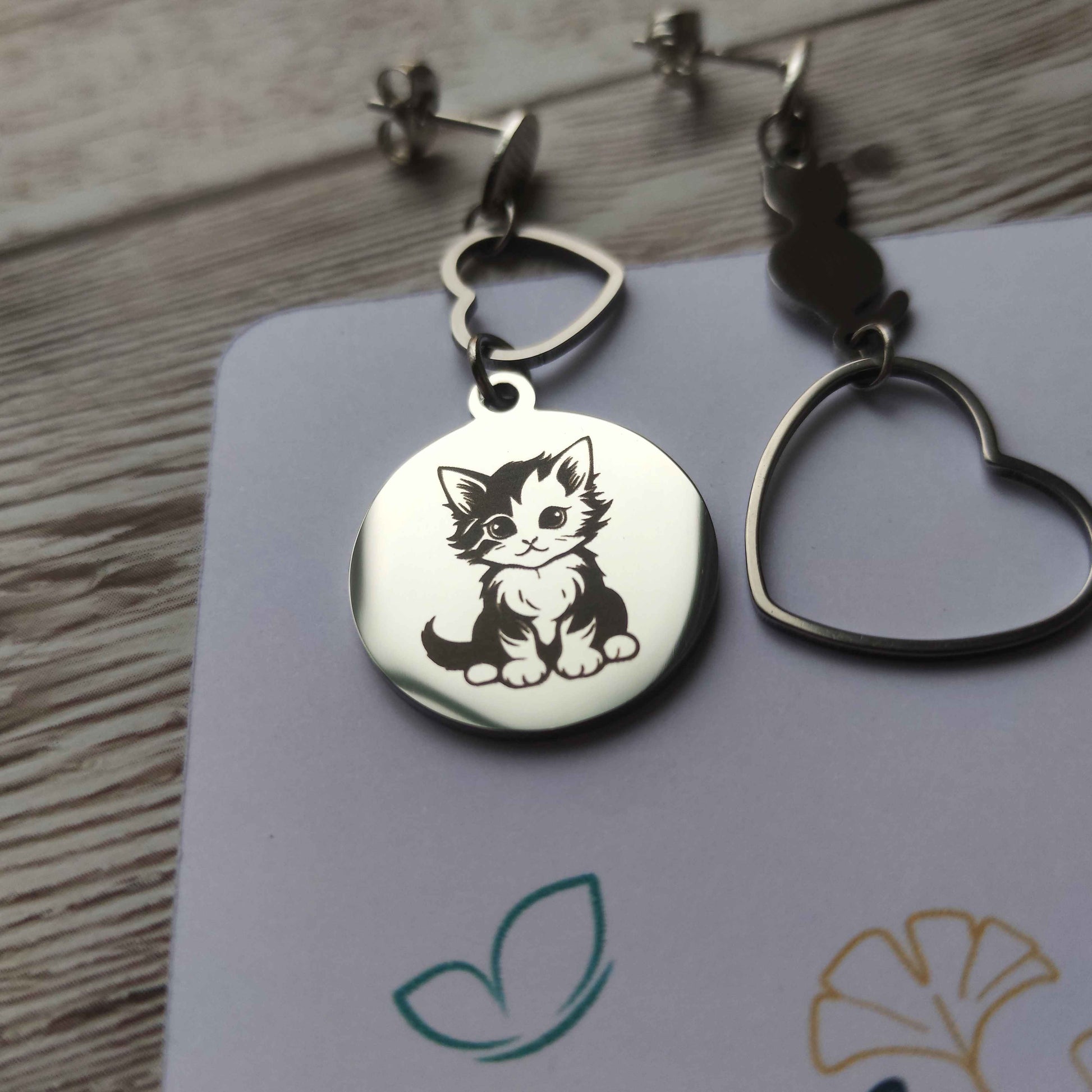 Gros plan gravure précision chat mignon sur boucle d'oreille artisanale.