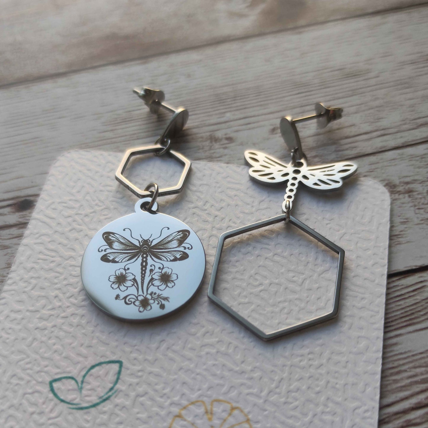 Boucles d'oreilles asymétriques Libellule 2 en acier inoxydable, une boucle gravée avec fleurs et une boucle ajourée, bijou artisanal effet miroir.
