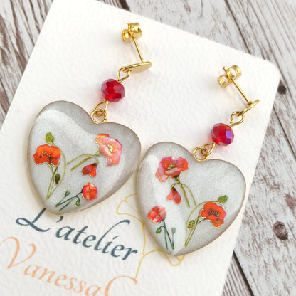 Boucles d'oreilles pendantes en forme de gros cœur blanc nacré avec véritables fleurs de coquelicots et cristal.