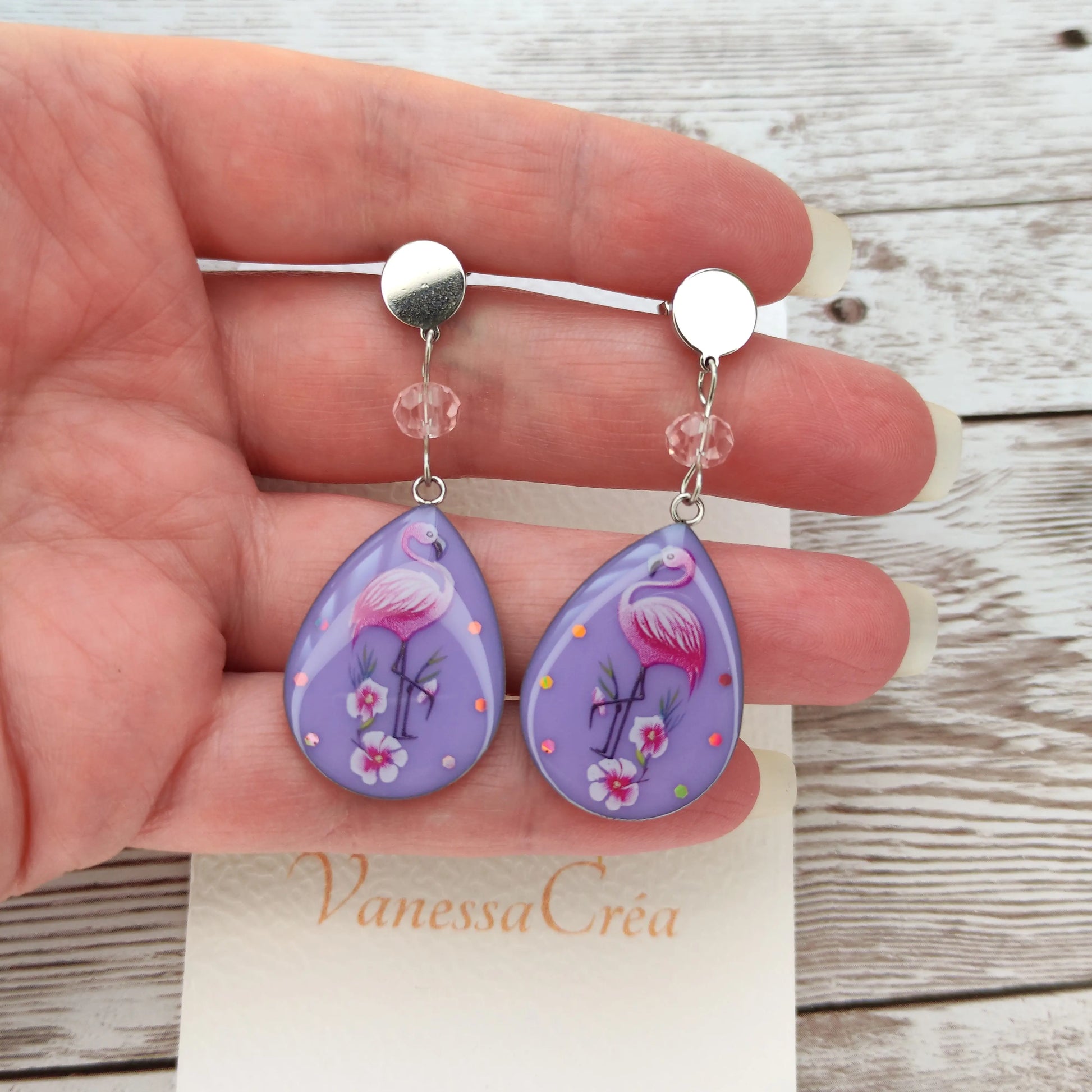 Détail du cristal à facettes et du motif flamant rose sur fond violet pailleté en résine.