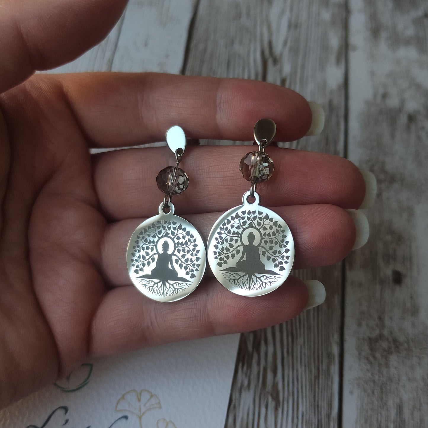 Boucles d'oreilles pendantes Arbre de Vie avec gravure Bouddha, cristal à facettes et acier inoxydable poli miroir.