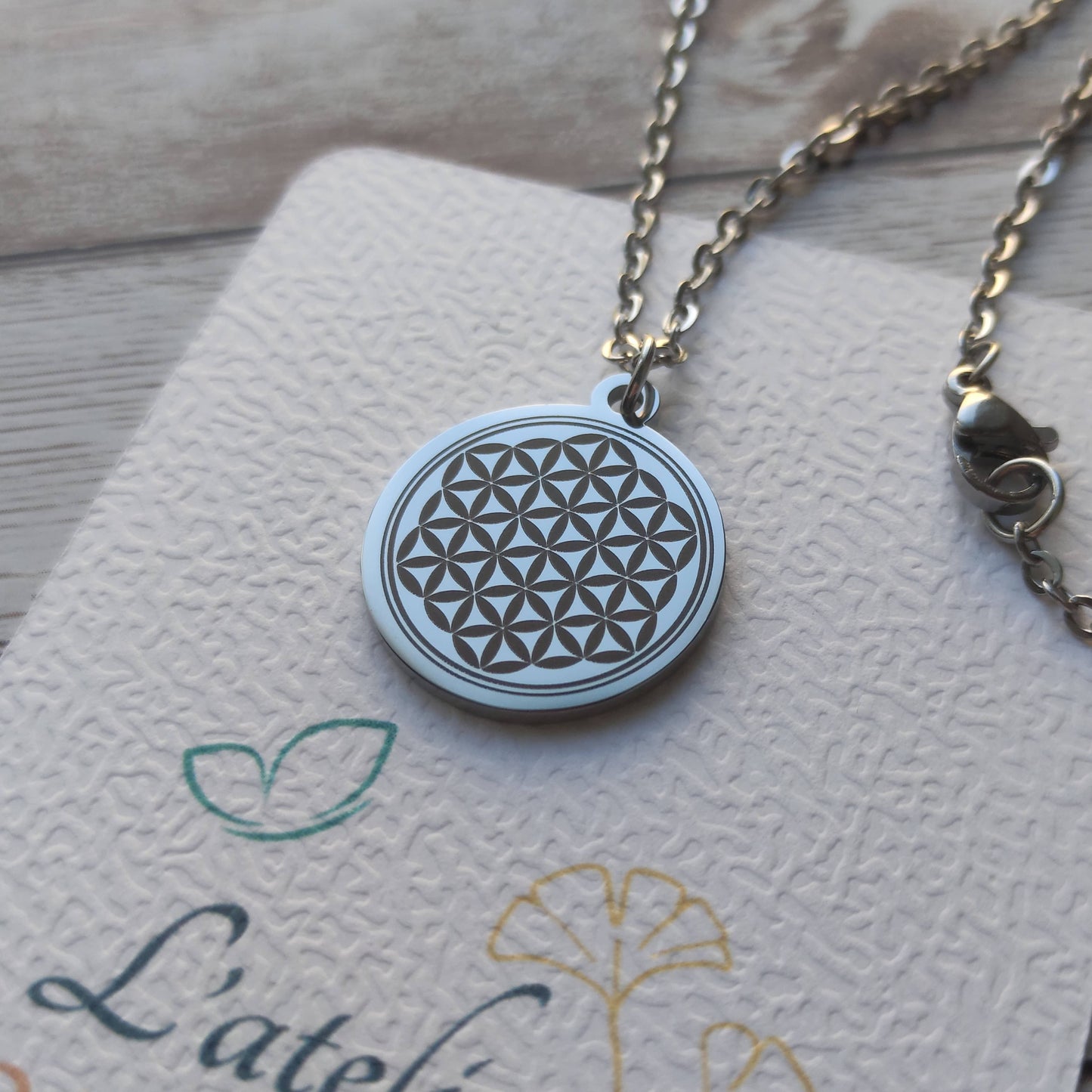 Collier Fleur de Vie personnalisé en acier inoxydable argenté poli miroir avec gravure de précision.