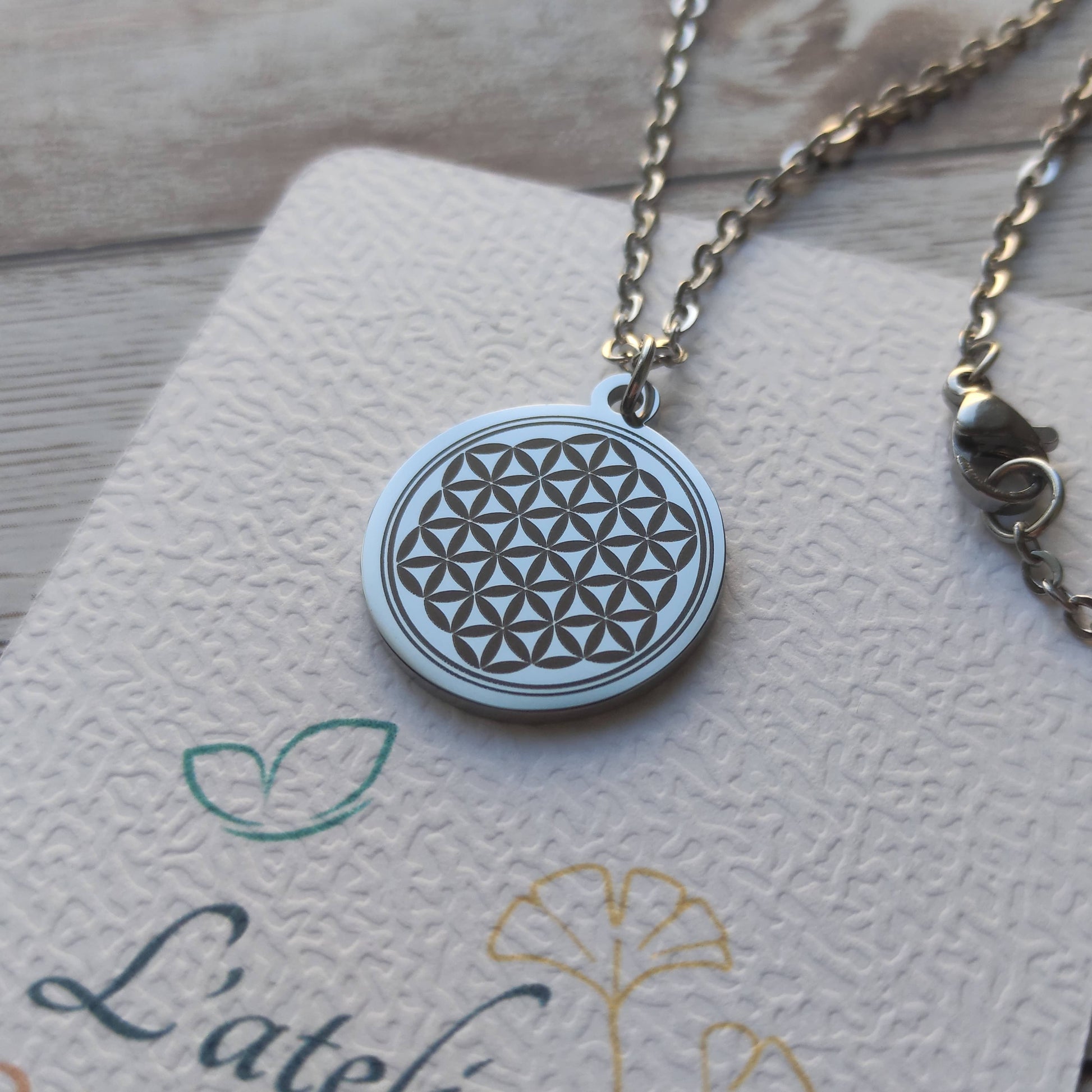 Collier Fleur de Vie personnalisé en acier inoxydable argenté poli miroir avec gravure de précision.