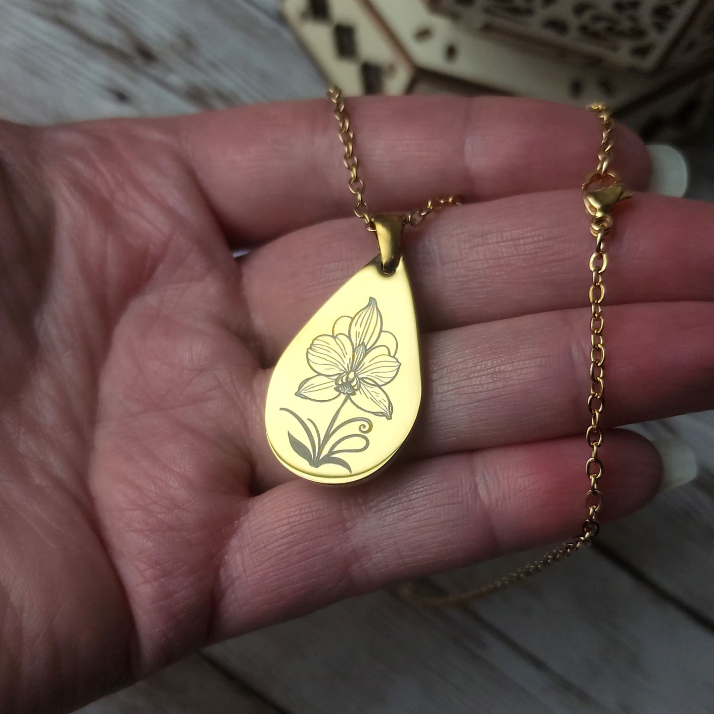 Collier orchidée personnalisé avec pendentif goutte en acier inoxydable doré poli miroir et gravure laser de précision.