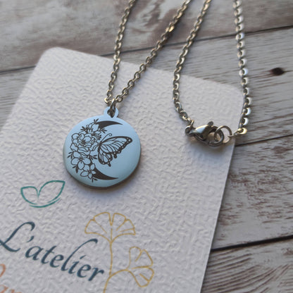Collier en acier inoxydable argenté poli miroir avec gravure laser d'un papillon sur une lune fleurie, pendentif rond 20mm.