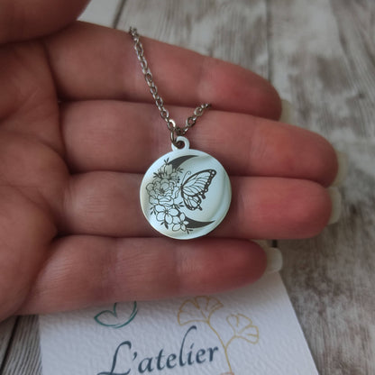 Collier en acier inoxydable argenté poli miroir avec gravure laser d'un papillon sur une lune fleurie, pendentif rond 20mm.