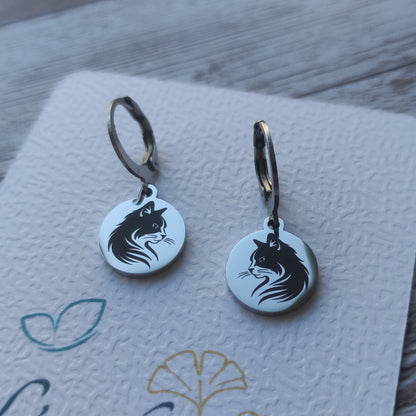 Paire de boucles d'oreilles dormeuses chat en acier inoxydable poli miroir avec gravure laser tête de chat sur médaillon rond.