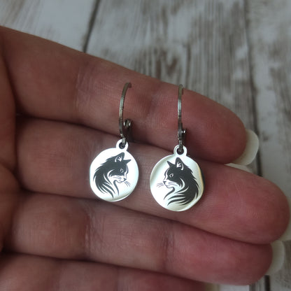 Paire de boucles d'oreilles dormeuses chat en acier inoxydable poli miroir avec gravure laser tête de chat sur médaillon rond.