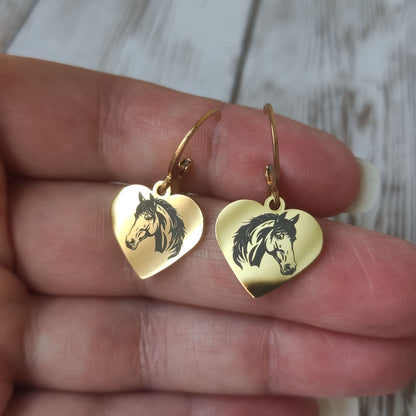 Paire de boucles d'oreilles dormeuses coeur cheval acier inoxydable avec gravure laser tête de cheval sur fond poli miroir.