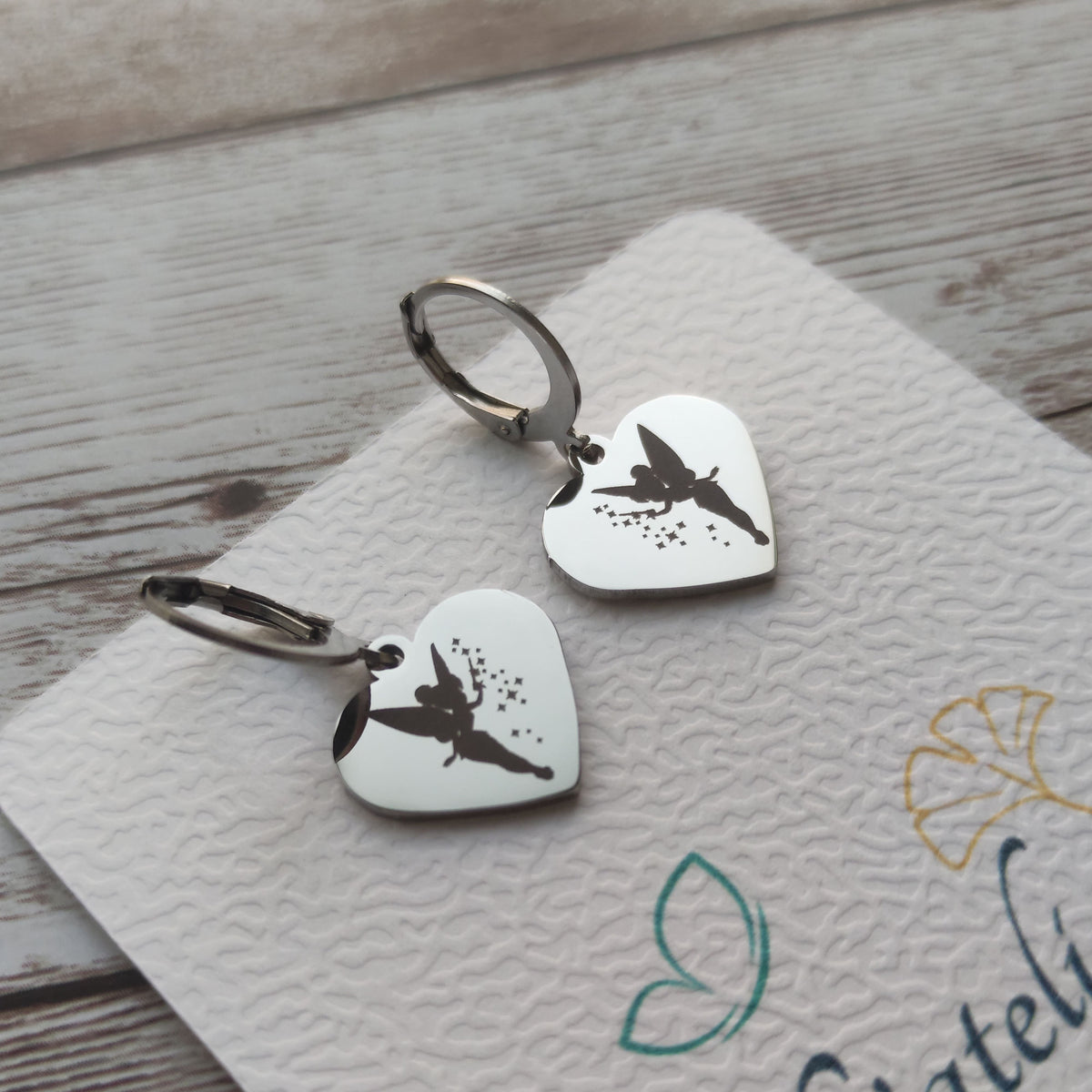 Boucles d'oreilles dormeuses coeur fée clochette acier inoxydable poli miroir avec gravure laser fée et baguette magique.