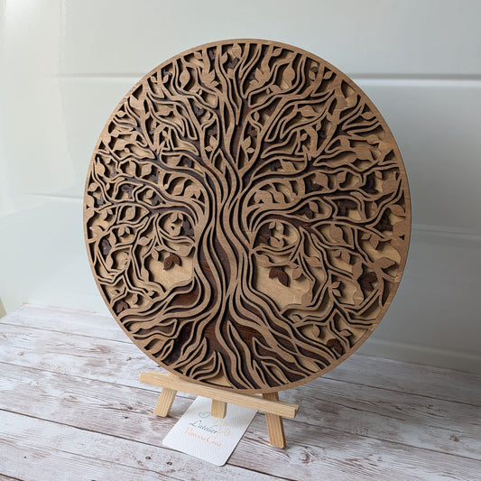Vue de face de l'Arbre de Vie en bois 3 couches, finition brou de noix, posé sur son support de présentation.