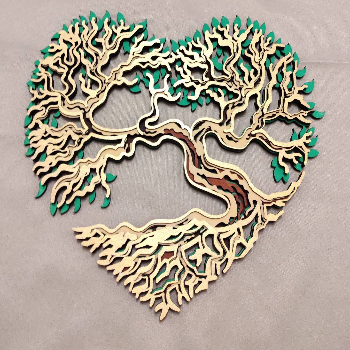 Arbre de Vie en bois en forme de cœur, décoration murale symbolique présentée sur un support en bois.