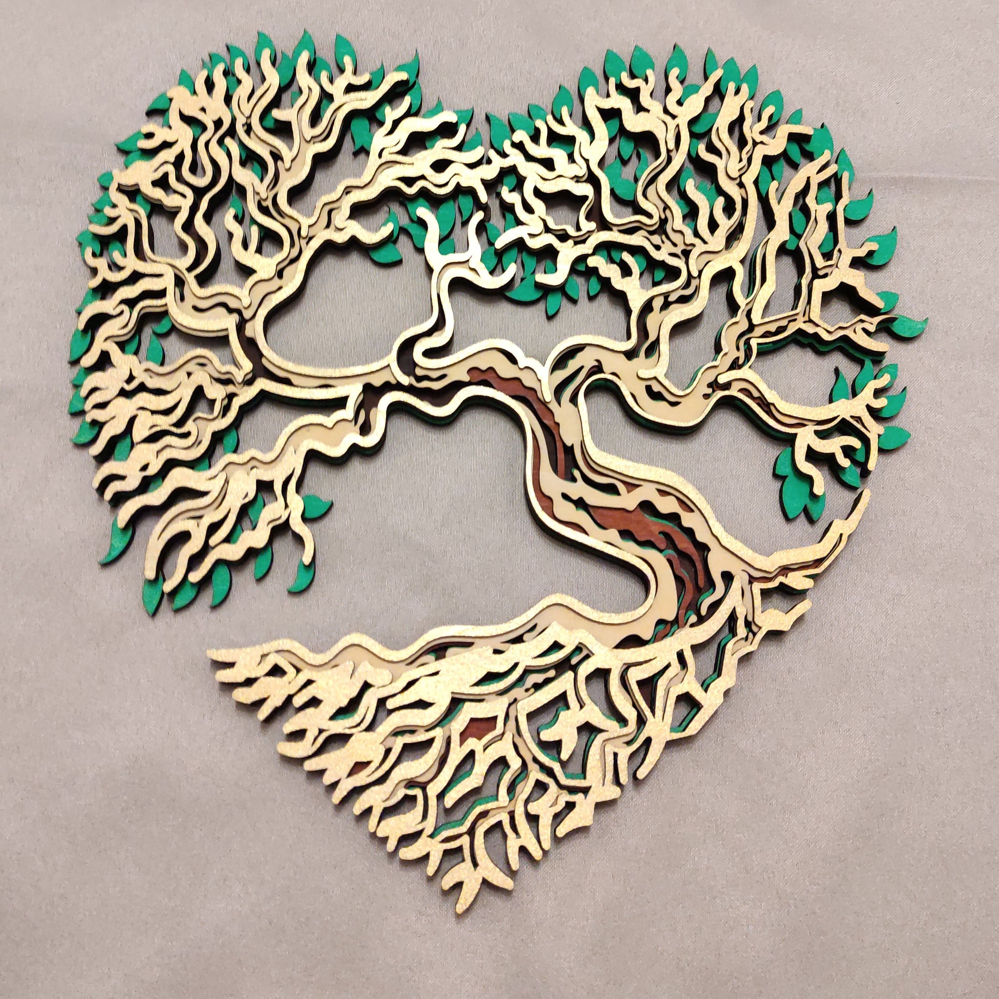Arbre de Vie en bois en forme de cœur, décoration murale symbolique présentée sur un support en bois.