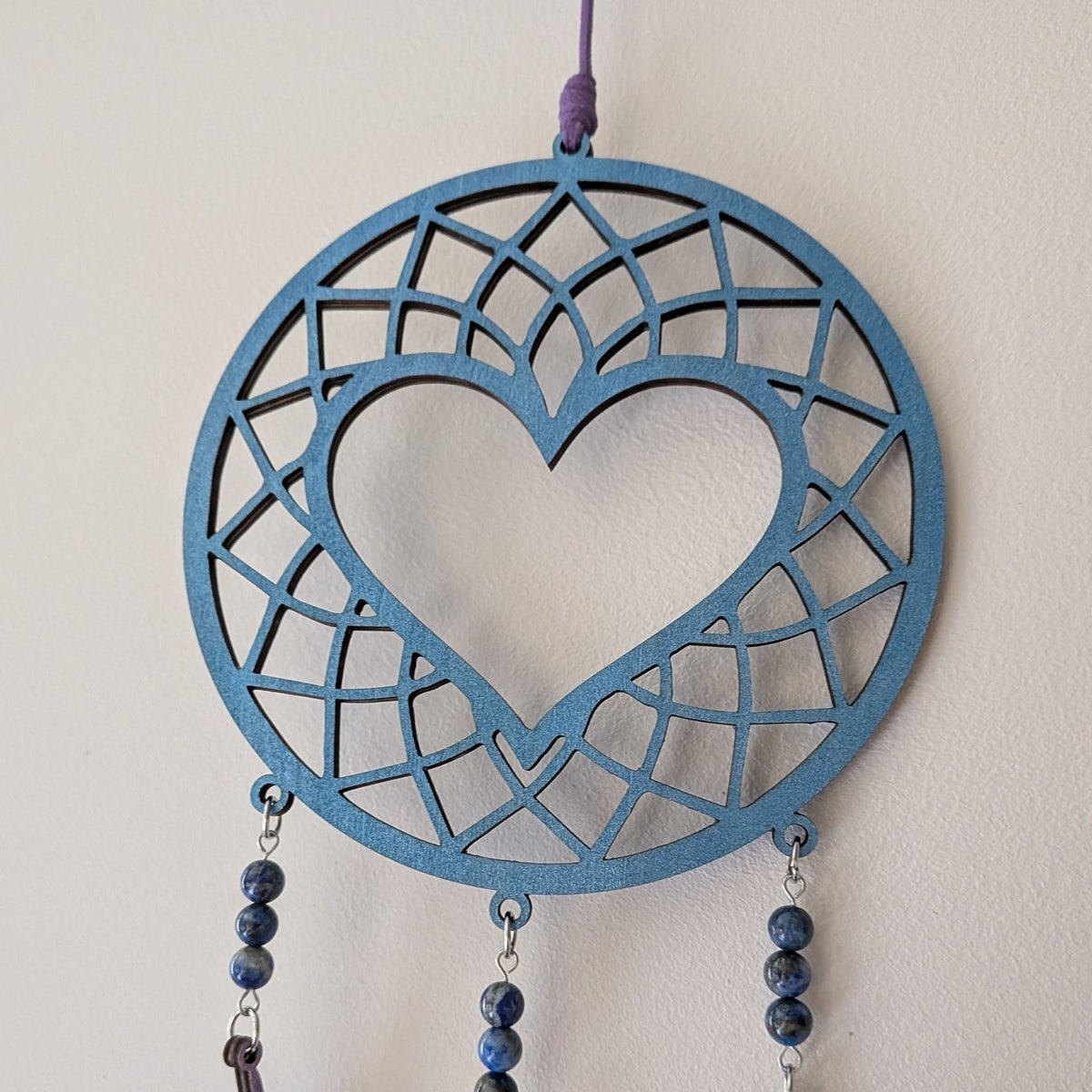 Détail du motif cœur de l'attrape-rêve en bois et lapis lazuli
