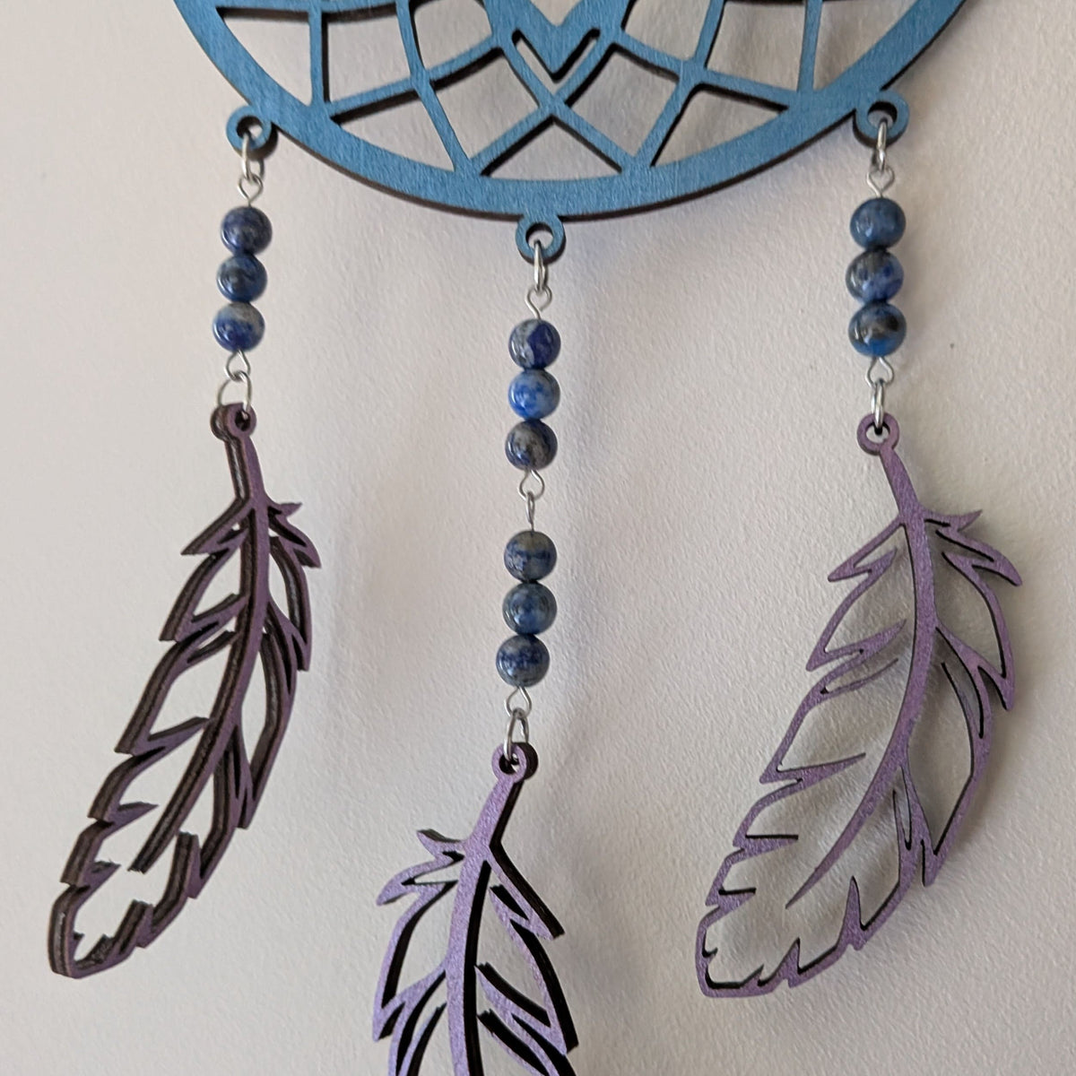 Zoom sur les perles de lapis lazuli de l'attrape-rêve en bois