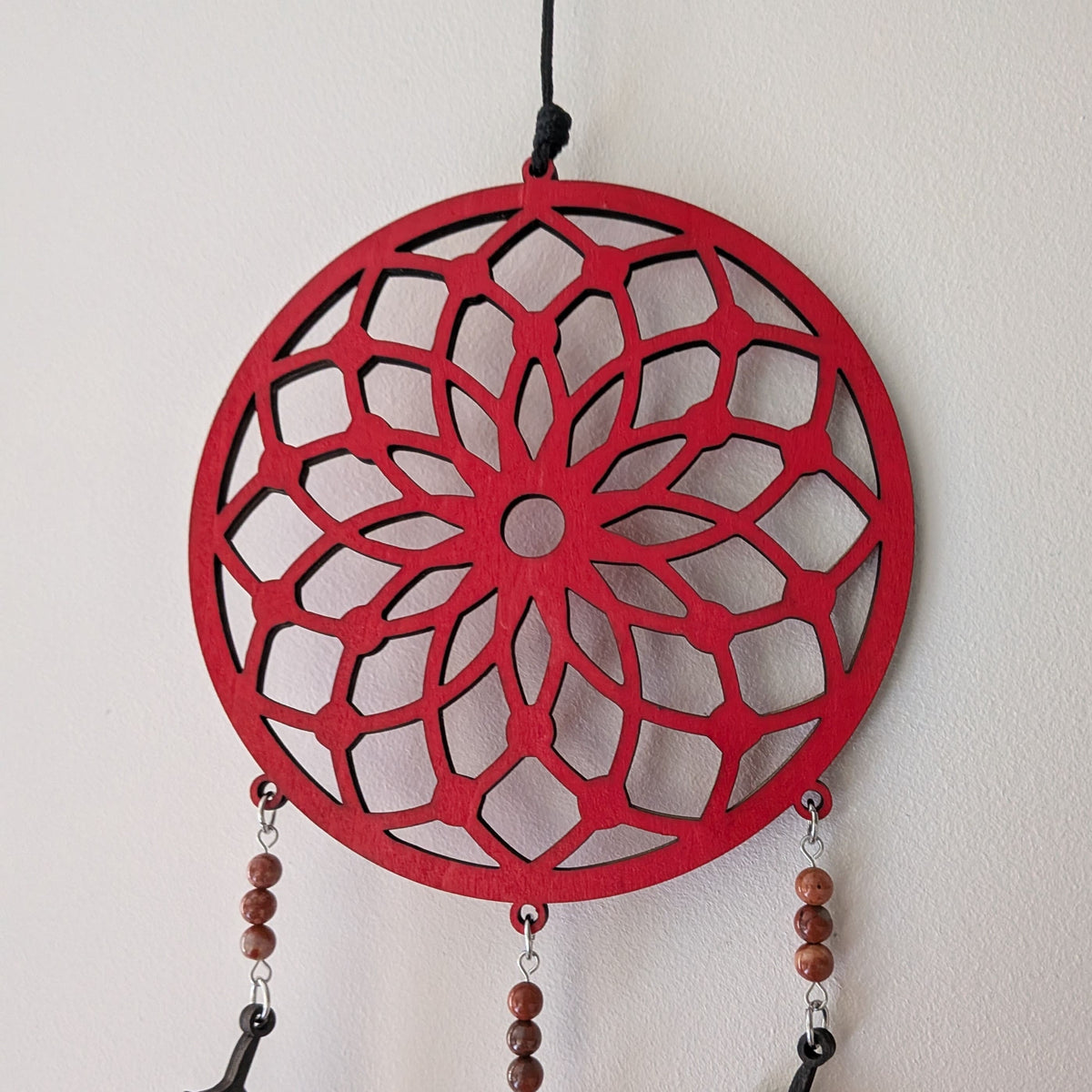 Détail du motif géométrique rouge de l'attrape-rêve jaspe rouge