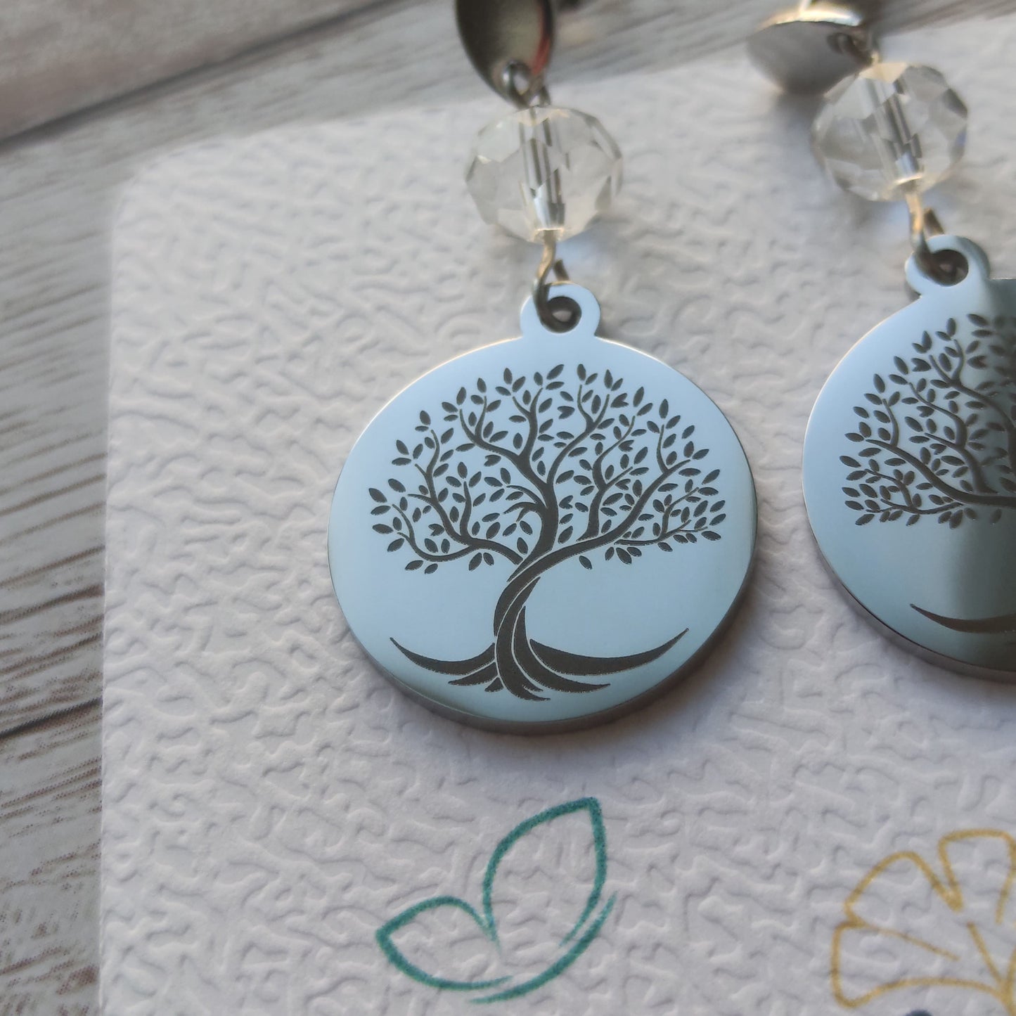 Boucles d'oreilles arbre de vie acier inoxydable avec cristal à facettes et médaillon poli miroir gravé au laser.