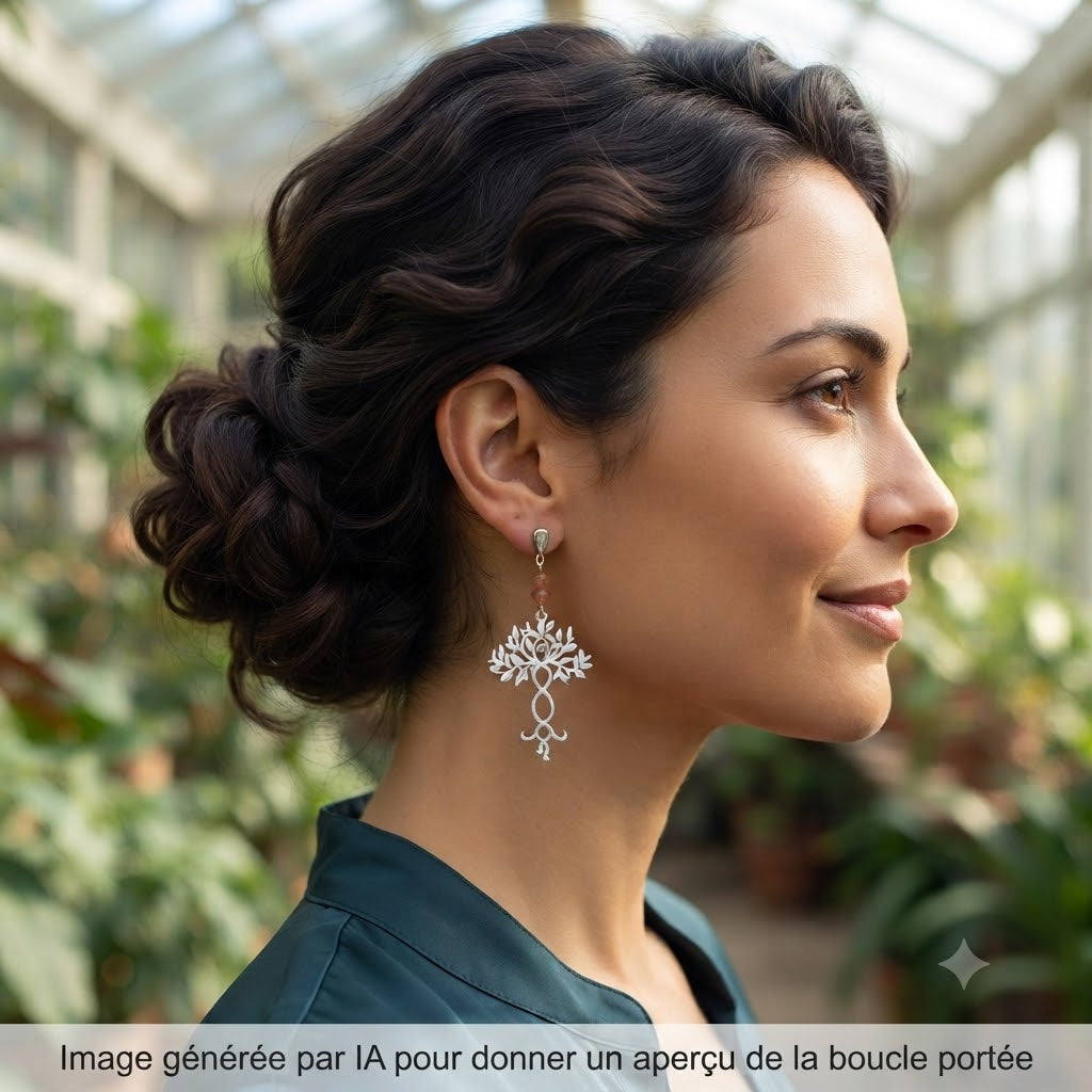 Femme portant des boucles d'oreilles pendantes arbre de vie argentées en extérieur.
