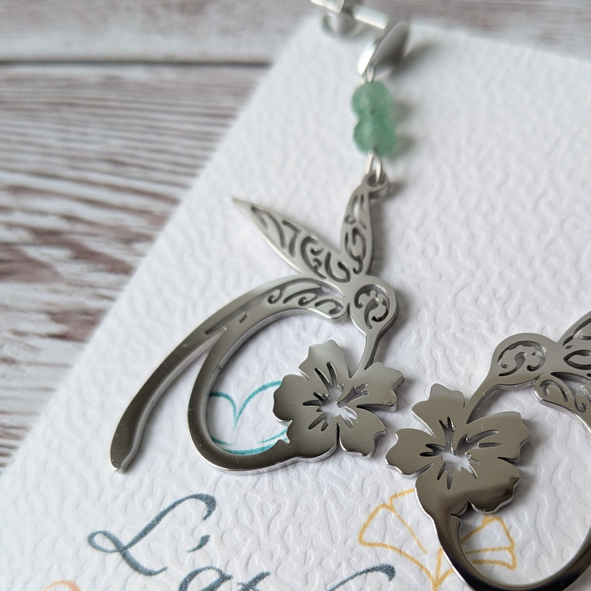 Vue de côté des boucles d'oreilles colibri argentées sur le carton de présentation.