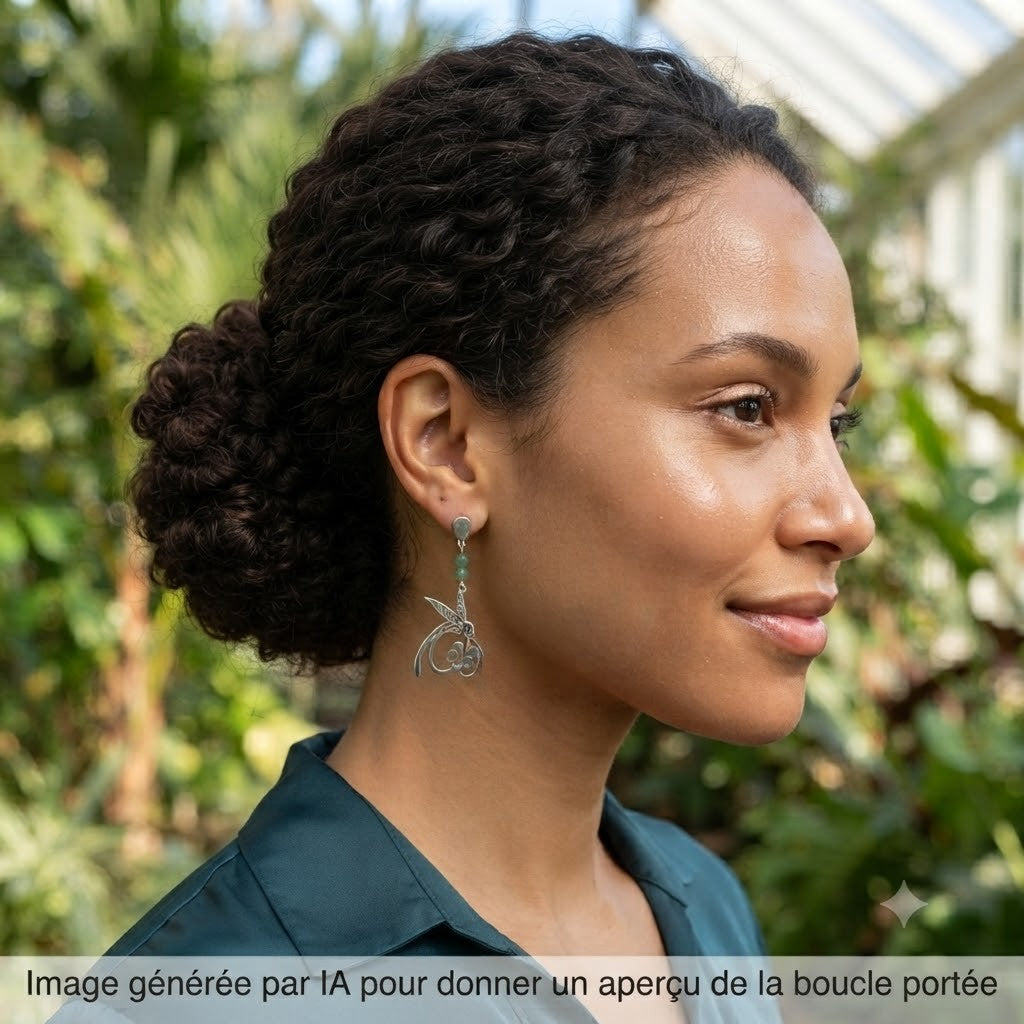 Femme portant des boucles d'oreilles pendantes colibri argentées.