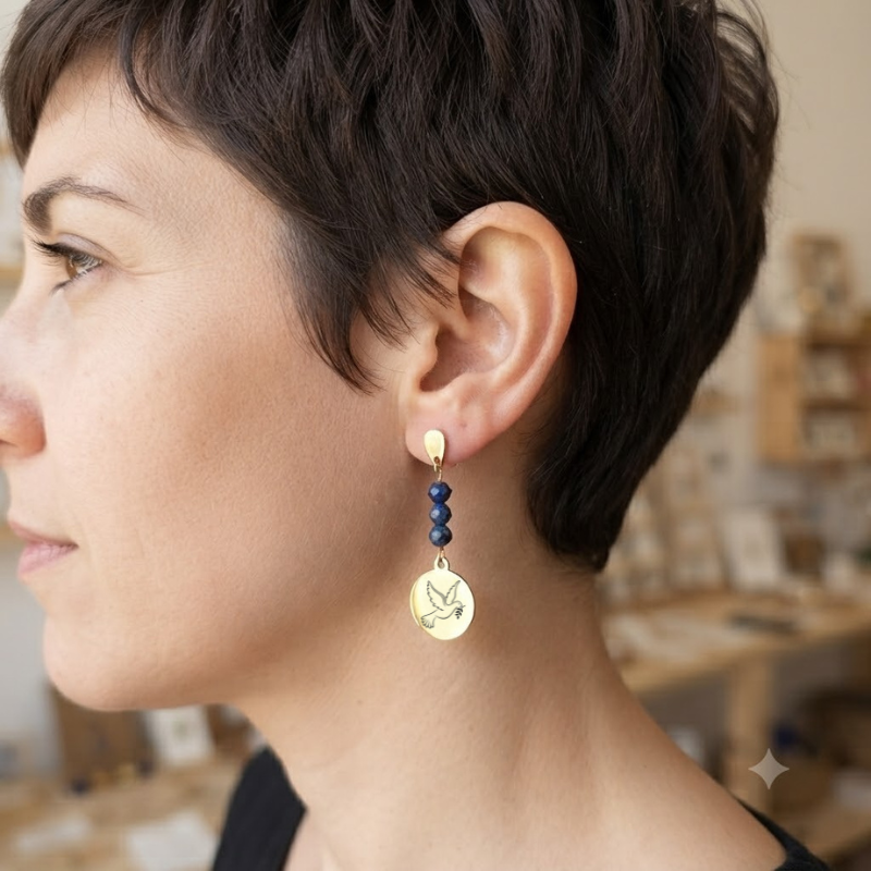 Vue de profil d'une femme portant des boucles d'oreilles pendantes motif colombe avec perles naturelles.