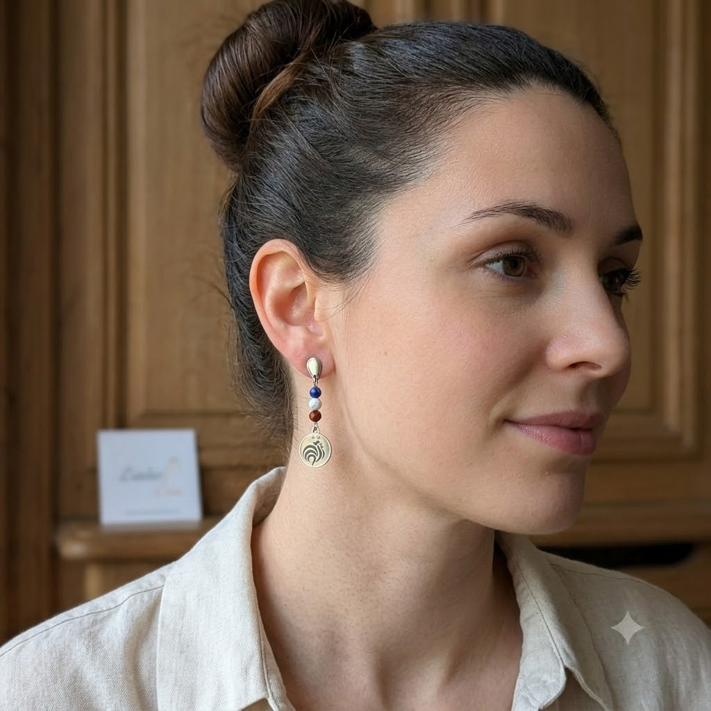 Vue de profil d'une femme portant des boucles d'oreilles pendantes motif coq aux couleurs tricolores.