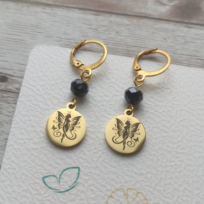 Boucles d'oreilles dormeuses en acier inoxydable avec cristal et médaillon gravé d'une fée papillon fini poli miroir.