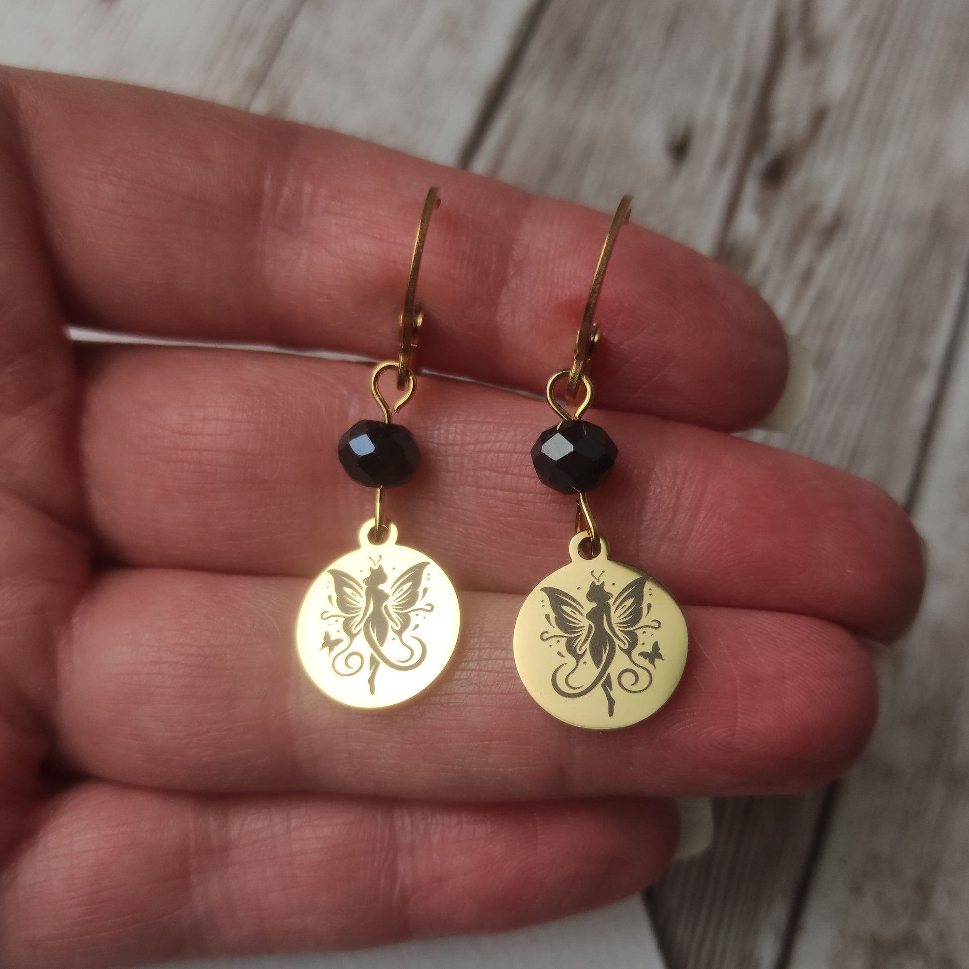 Boucles d'oreilles dormeuses en acier inoxydable avec cristal et médaillon gravé d'une fée papillon fini poli miroir.