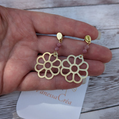 Boucles d'oreilles fleur ajourée en laiton avec perles de rhodonite de 4 mm, présentées sur la main avec la carte de l'atelier Vanessa Créa.