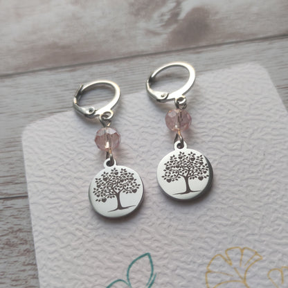 Boucles d'oreilles avec fermoir levier français, cristal à facettes rose 
et médaillon rond en acier inoxydable gravé d'un arbre de vie avec cœurs.