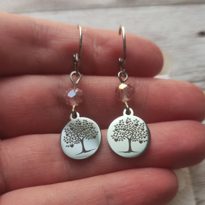 Boucles d'oreilles avec fermoir levier français, cristal à facettes rose et médaillon rond en acier inoxydable gravé d'un arbre de vie avec cœurs.