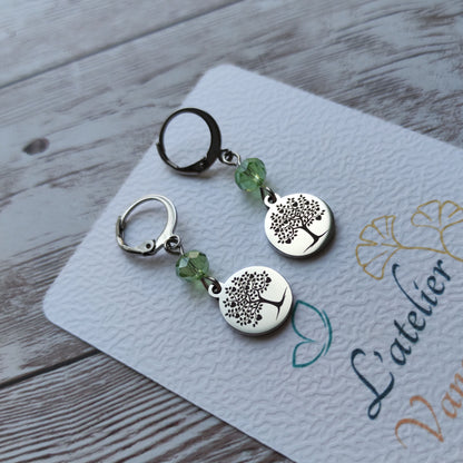 Boucles d'oreilles avec fermoir levier français, cristal à facettes vert et médaillon rond en acier inoxydable gravé d'un arbre de vie avec cœurs.