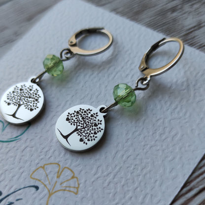 Boucles d'oreilles avec fermoir levier français, cristal à facettes et médaillon rond en acier inoxydable gravé d'un arbre de vie avec cœurs.