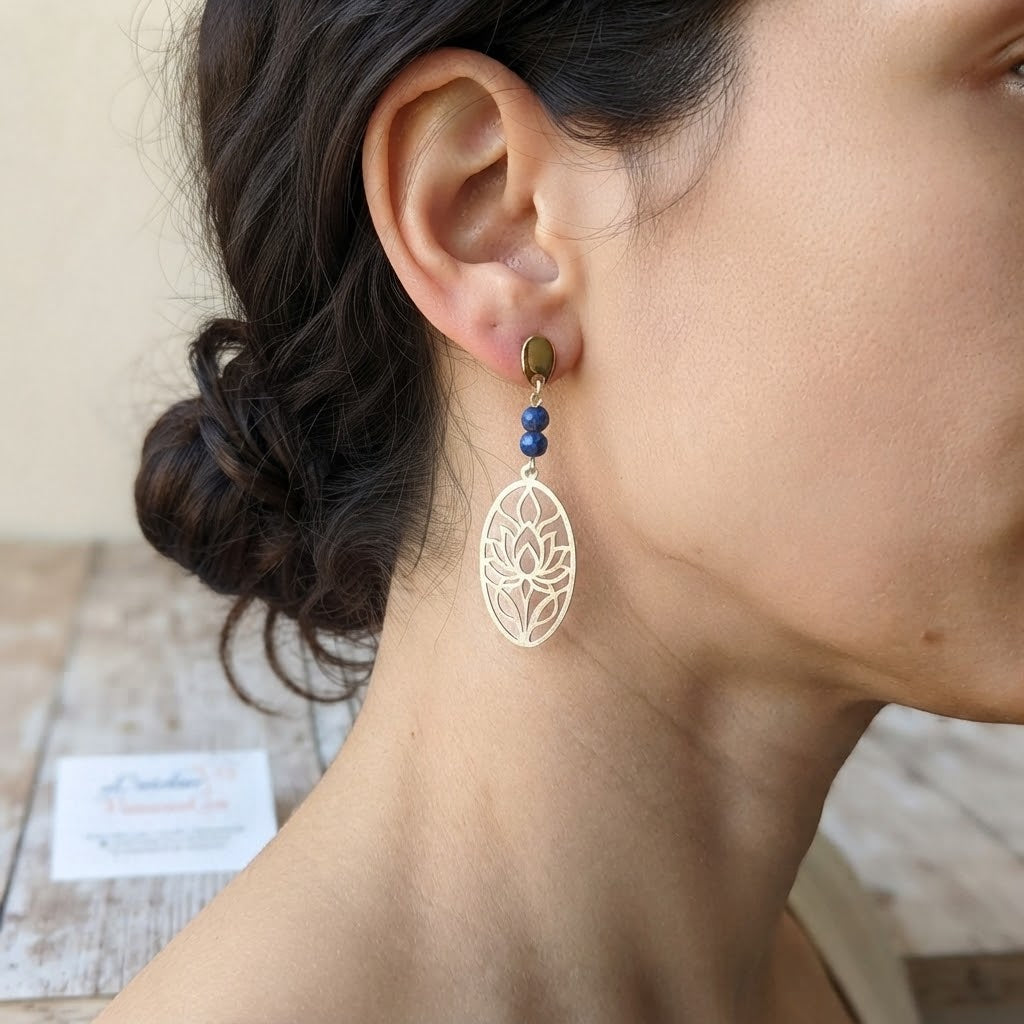 Boucles d'oreilles lotus ajouré en acier inoxydable et lapis-lazuli portées, illustrant leur rendu élégant et leur taille.