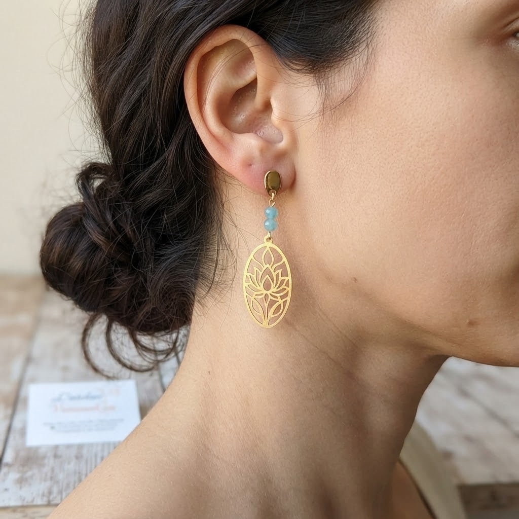 Boucles d'oreilles lotus ajouré en laiton et amazonite portées, mettant en valeur leur taille et leur élégance.
