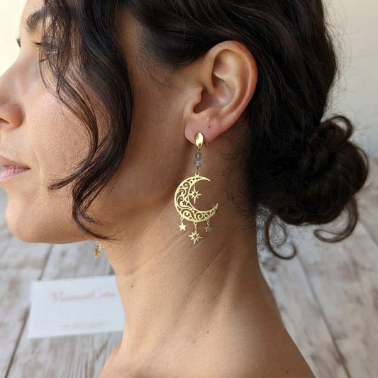Boucles d'oreilles pendantes lune et étoiles en laiton et labradorite portées, mettant en valeur leur élégance et leur dimension.