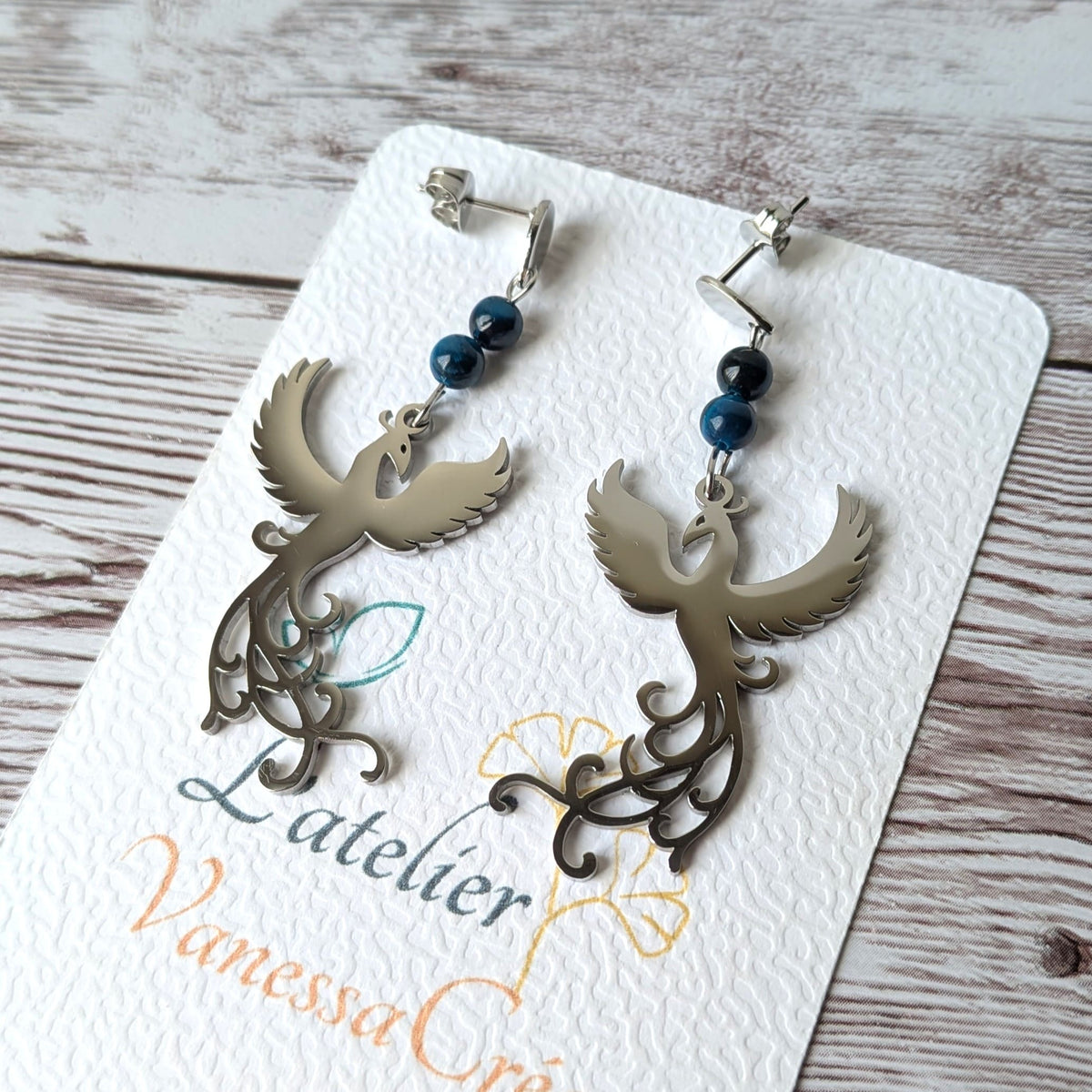 Boucles d'oreilles phénix argentées avec perles sur support L'atelier Vanessa Créa.