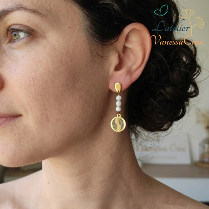 Vue de profil d'une femme portant des boucles d'oreilles pendantes motif plume avec perles naturelles.