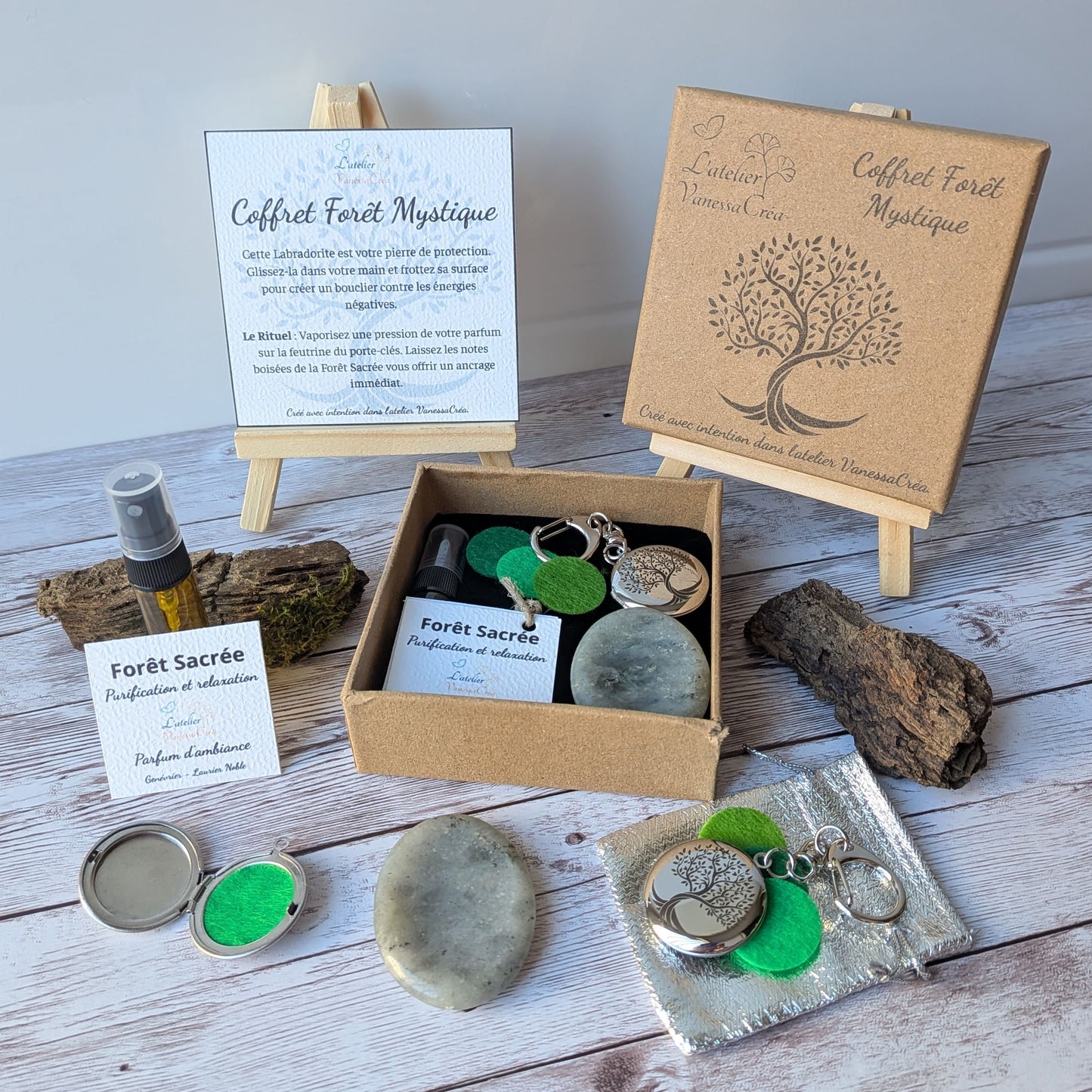 Vue d'ensemble du coffret lithothérapie et aromathérapie Forêt Mystique, avec son parfum bio, son galet de labradorite et son porte-clés médaillon ouvert sur fond de bois.