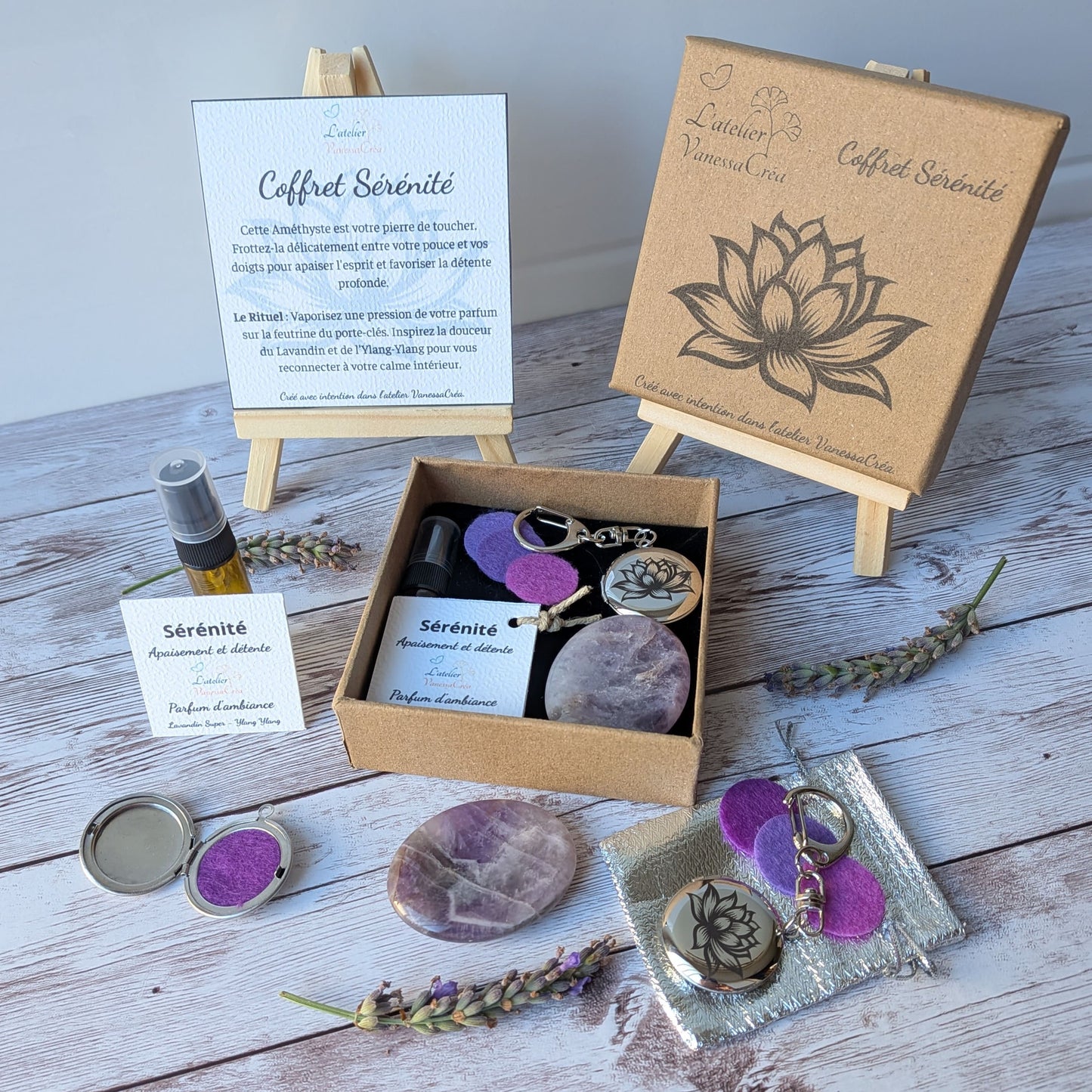 Vue d'ensemble du coffret lithothérapie et aromathérapie Sérénité, avec son parfum bio, son galet d'améthyste et son porte-clés fleur de lotus sur fond de bois.
