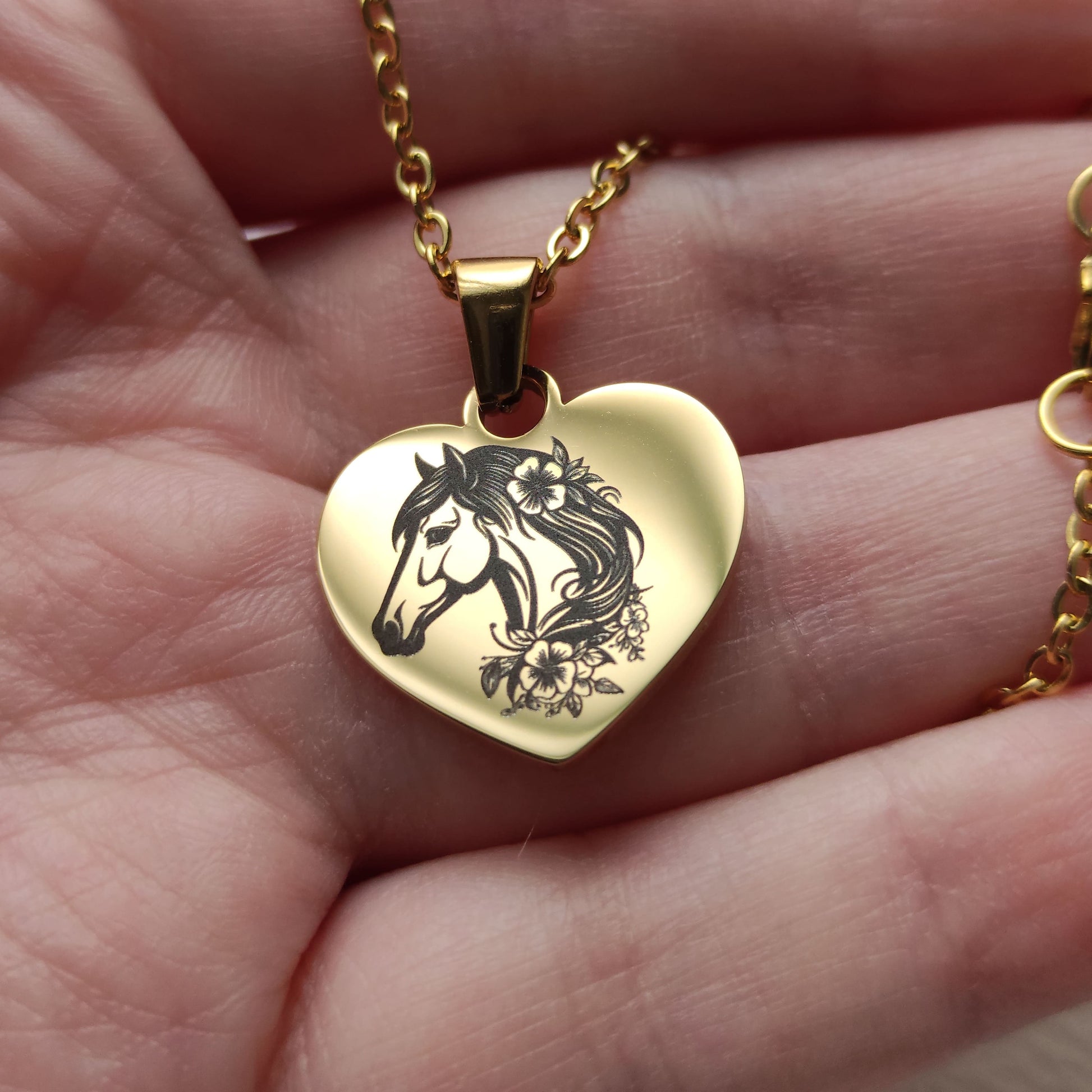 Collier pendentif cœur en acier poli miroir avec gravure tête de cheval et fleurs de profil.