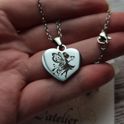 Collier en acier inoxydable poli avec pendentif cœur de 2,5 cm gravé d'une fée envoyant des cœurs.
