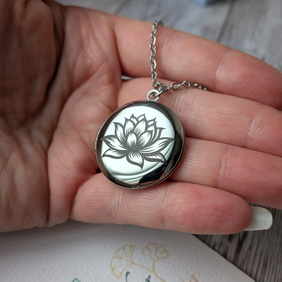Collier diffuseur d'huiles essentielles Fleur de Lotus présenté dans la main
