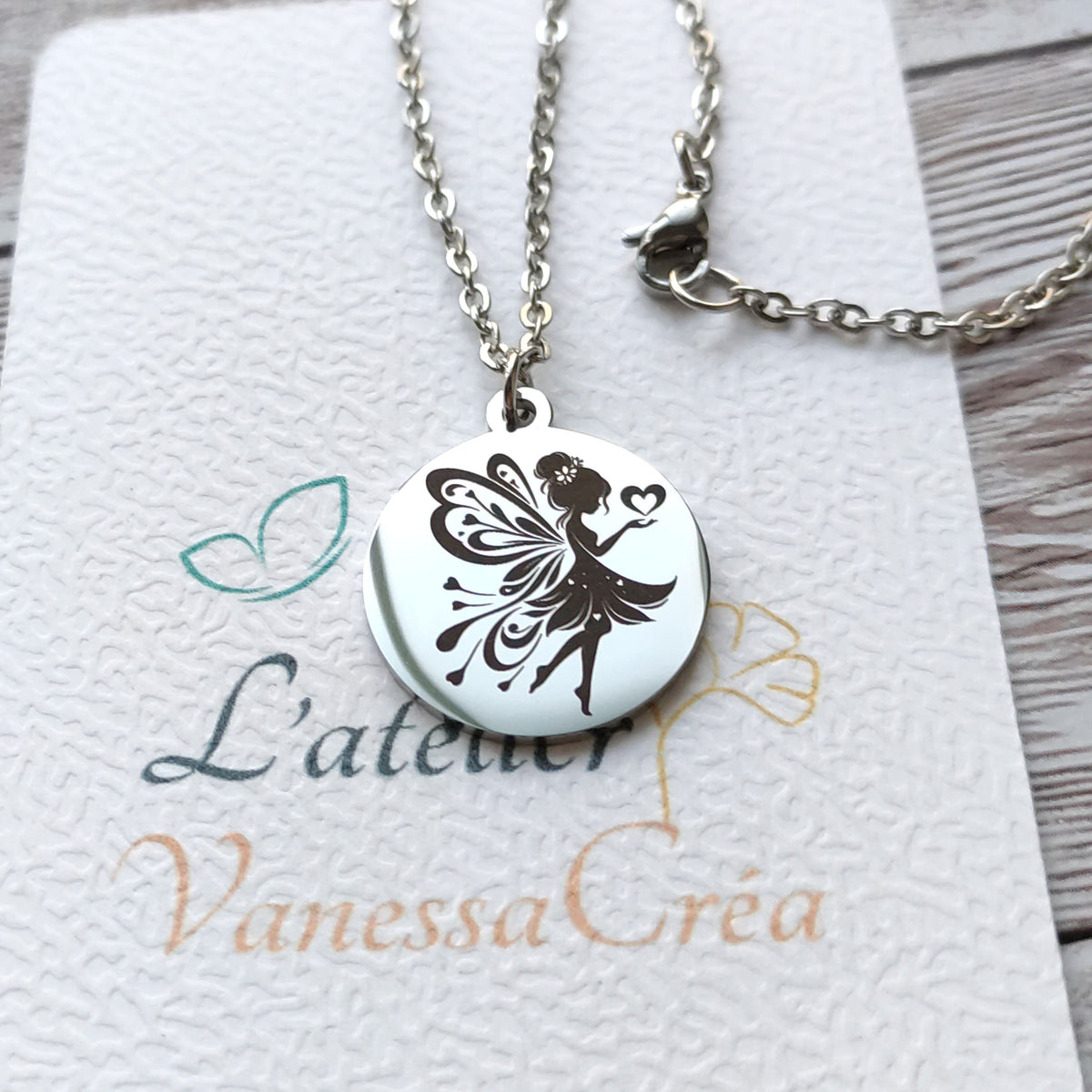 Collier pendentif rond en acier inoxydable poli miroir avec gravure laser d'une fée et de cœurs.