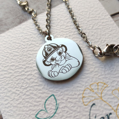 Collier médaille ronde en acier poli miroir avec gravure de Simba portant un casque de pompier.