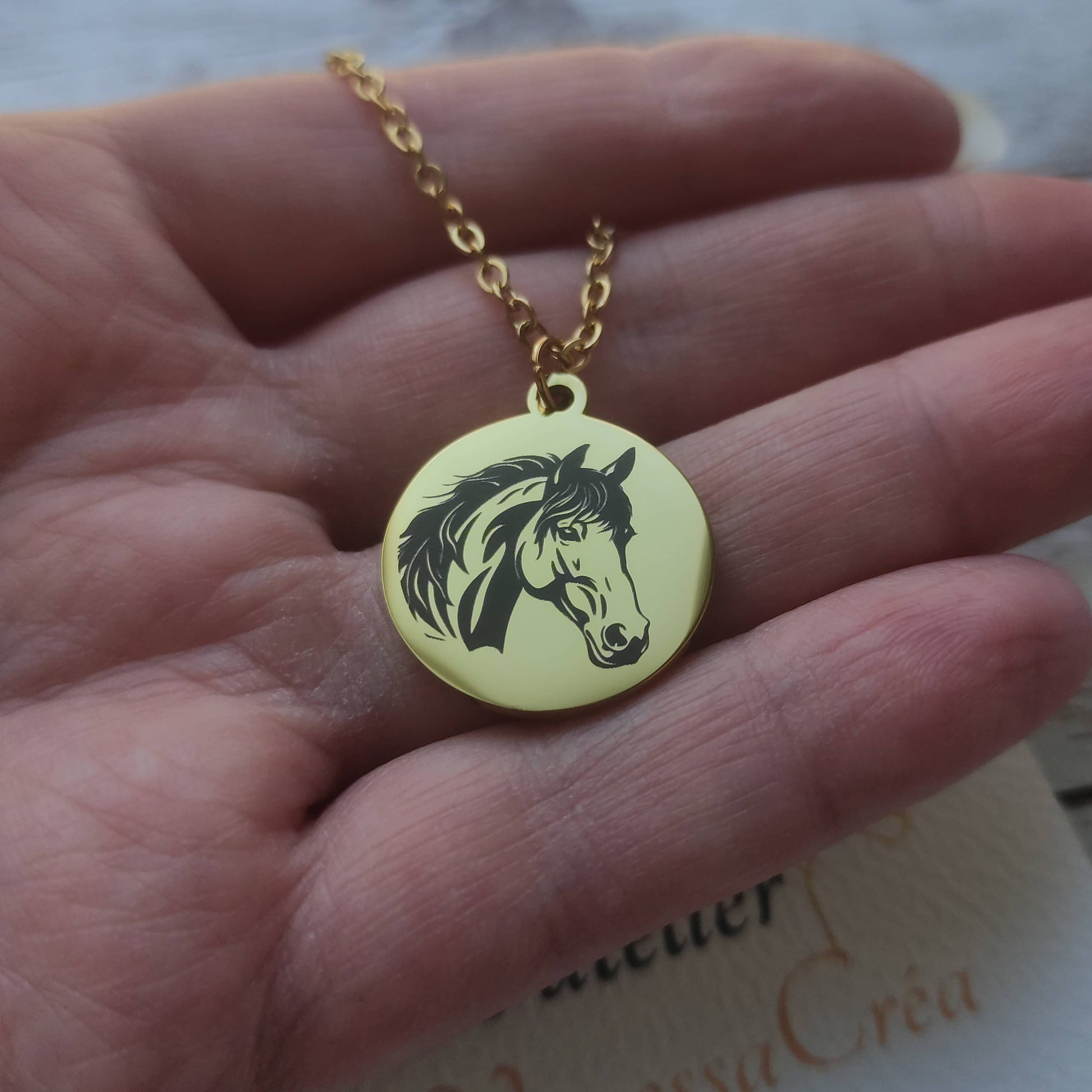 Collier médaille ronde en acier poli miroir avec gravure de précision d'une tête de cheval et chaîne à maillons.