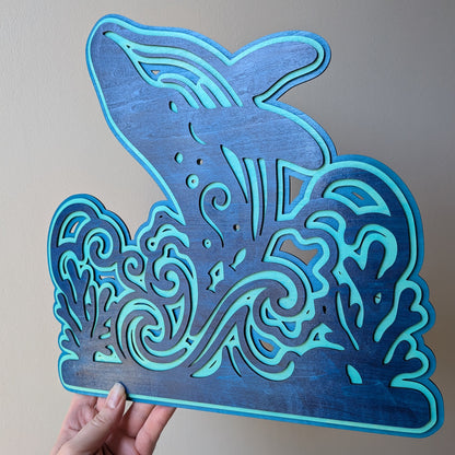 Décoration baleine en bois tenue à la main pour montrer l'échelle
