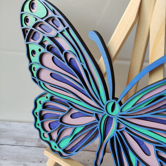 Gros plan sur les détails et les couleurs des ailes du papillon en bois, mettant en valeur la précision de la découpe.
